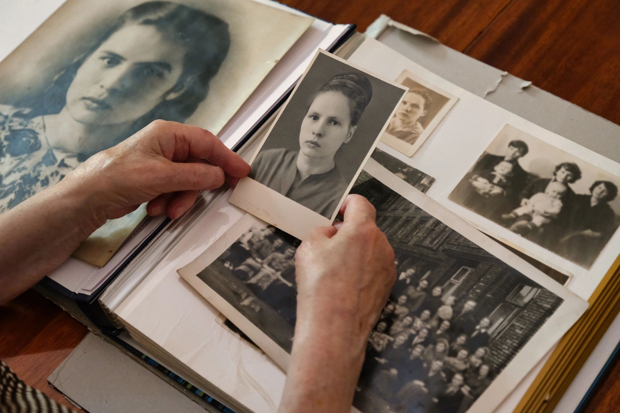 Hands sorting archival photographs and documents